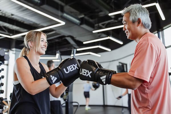 Male and female members fist-bumping after workout