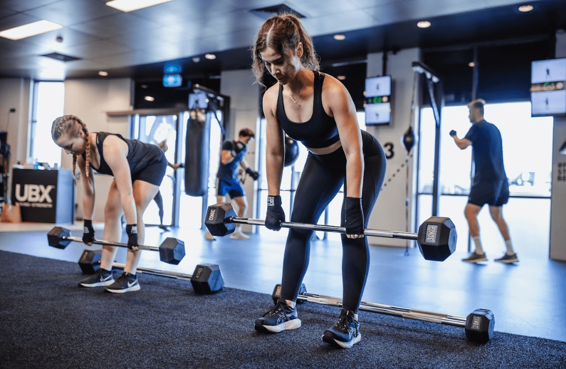 Female athlete lifting weights as part of strength training at UBX Training Ealing.