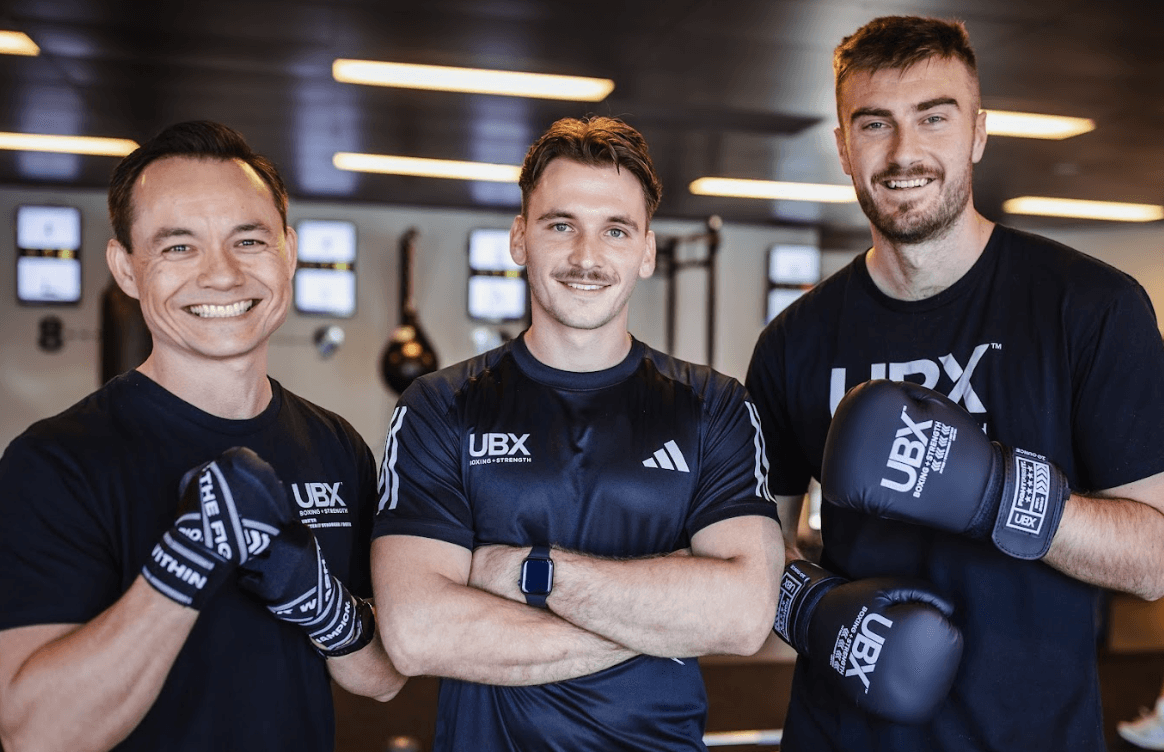 Three UBX Training Ealing coaches standing in front of the camera, showcasing the gym’s expert training team.