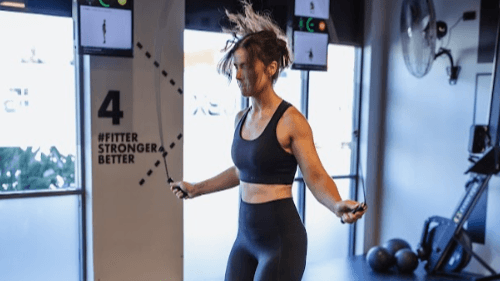 Woman improving boxing footwork and agility by jumping rope during UBX workout